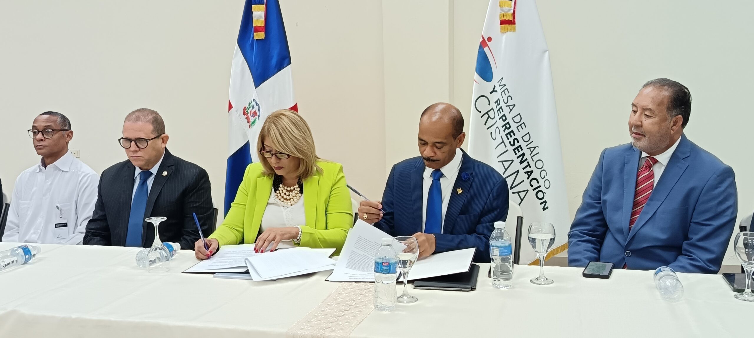 El obispo Reynaldo Franco Aquino y la Dra. Bethania Martinez durante la firma del acuerdo